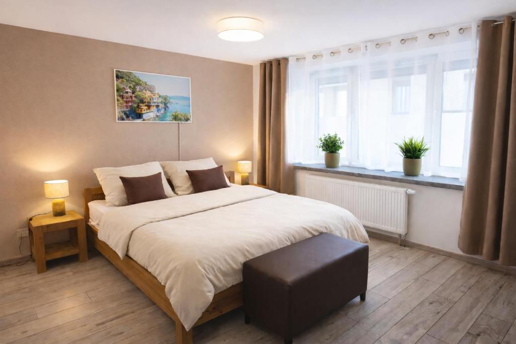 a bedroom with a large bed and two windows at Ferienwohnung Saupe in Königshain