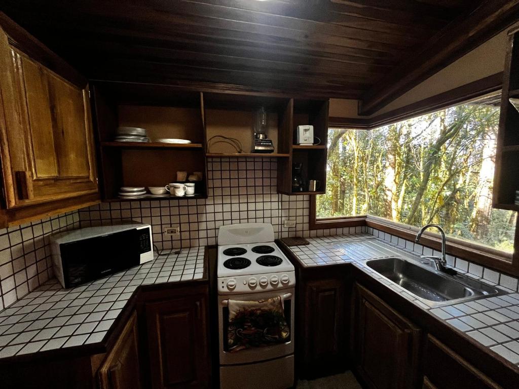 a kitchen with a stove and a sink and a window at Cabaña kloski in Damita