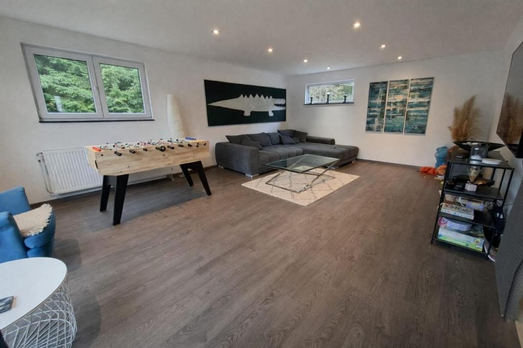 a living room with a ping pong table and a couch at The Eau Rouge 600m from the entrance of the circuit in Stavelot