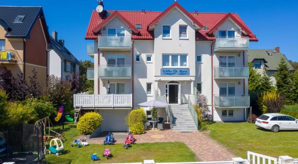a house with a playground in front of it at Willa Di Mare in Karwia