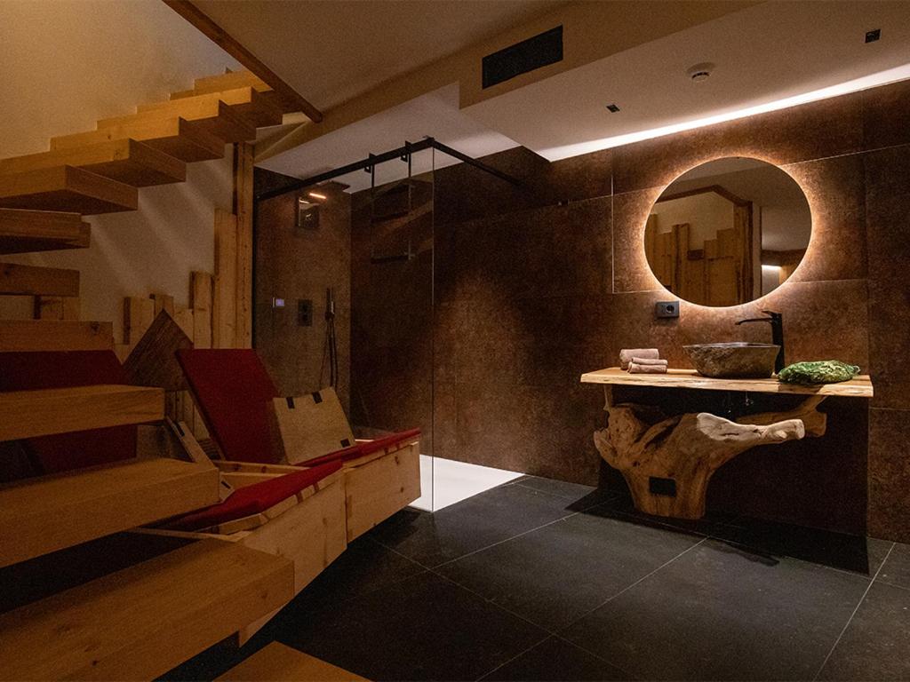a bathroom with a staircase and a sink and a mirror at SKY LOVE Luxury Chalet in Andalo
