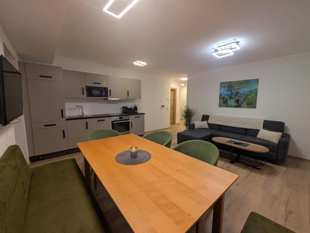 a living room with a table and a couch at Apartment Auszeit am See in Uttendorf