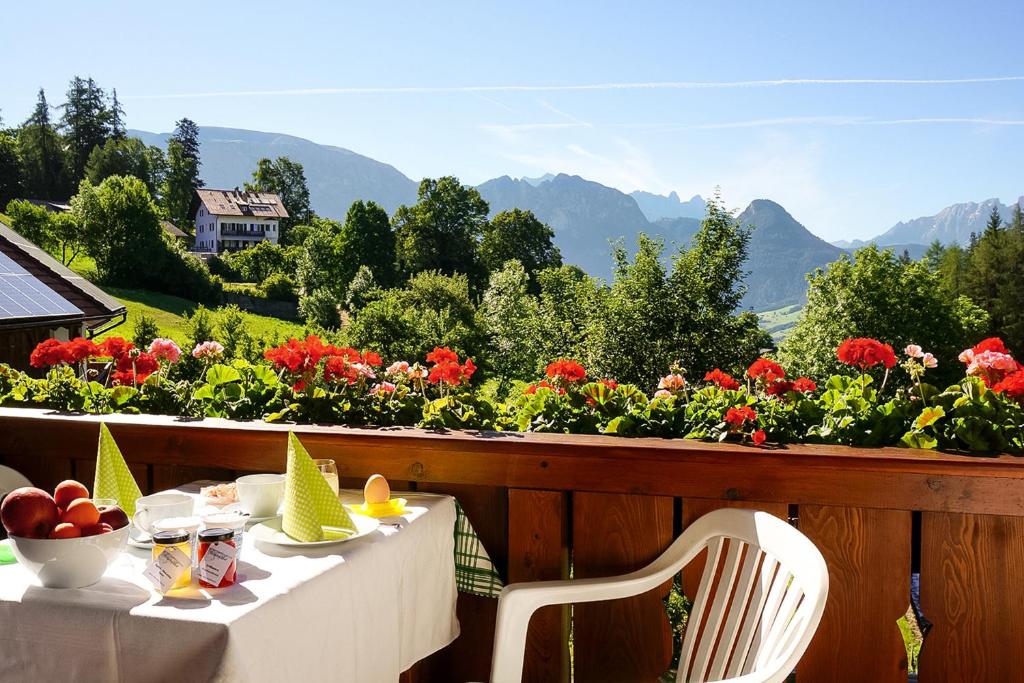 Ein Tisch und Stühle auf einem Balkon mit Blumen in der Unterkunft Ferienwohnung Marienkäfer Rückzugsort inmitten der Natur mit Bergblick in Klobenstein