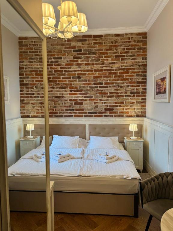 a bedroom with a bed and a brick wall at Sempre B&B in Płock