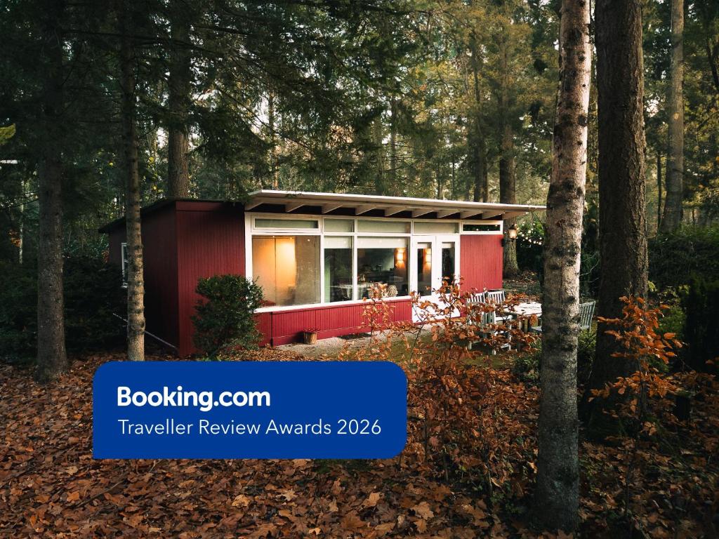 a house in the woods with the text booking convention traveller review awards at Natuurhuisje het Jagertje in Emst