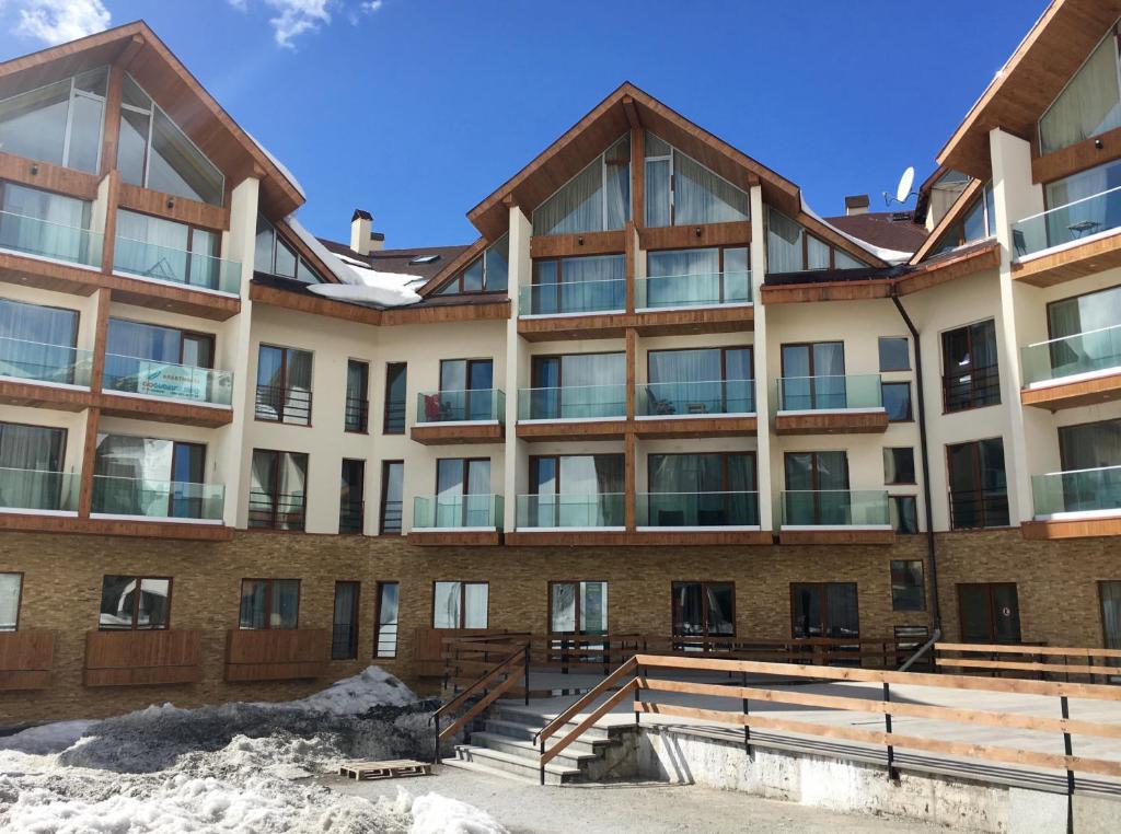 an apartment building with snow in front of it at Apartments 315 New Gudauri 2 blok in Gudauri