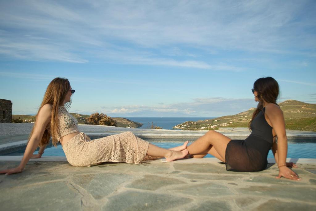 two women sitting on the sand on the beach at Petra Vista Retreats in Otziás