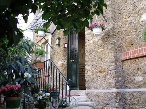 a stone building with a black door with flowers on it at Hotel Windsor Home in Paris
