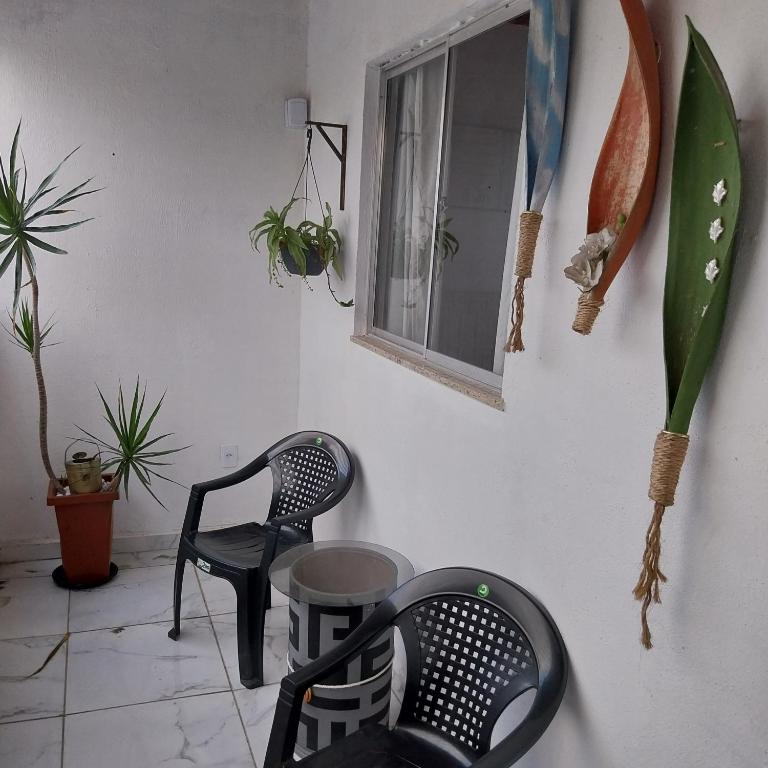 a room with two chairs and a window at Espaço familiar in Saquarema