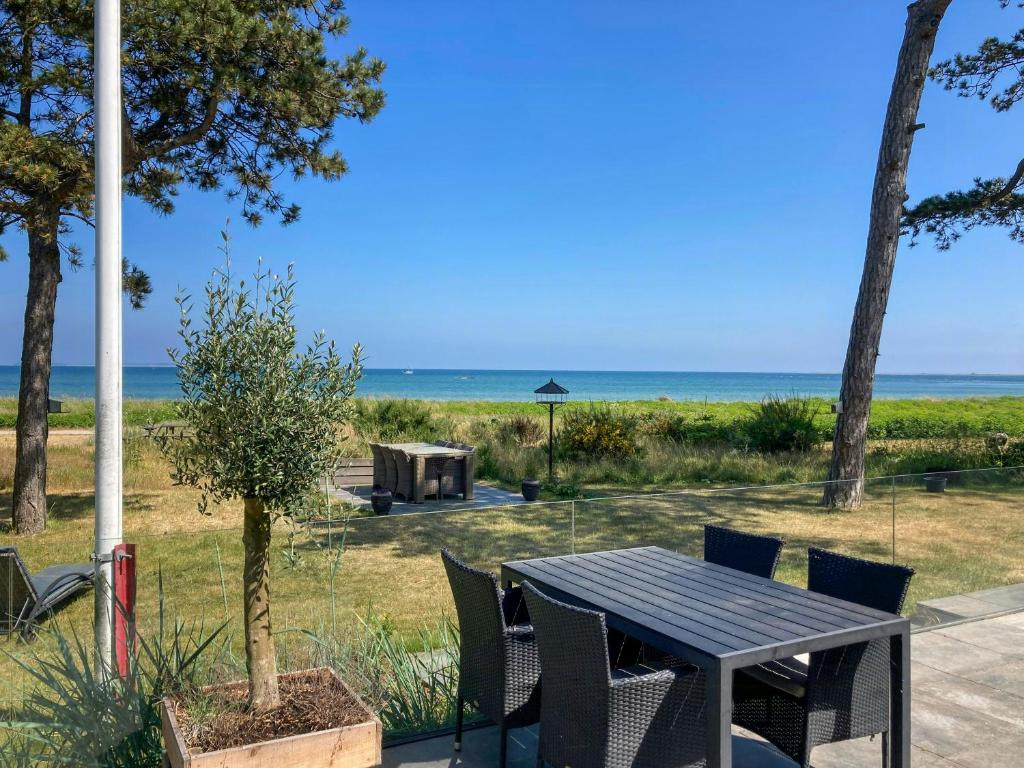 a table and chairs with the beach in the background at Beach Villa With Private Pier In Hou in Odder
