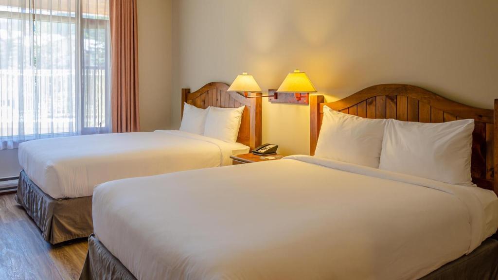 a hotel room with two beds and a window at Cahilty #120 home in Sun Peaks