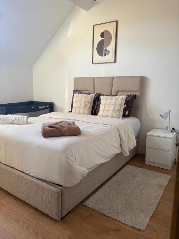 un dormitorio con una cama grande con sábanas y almohadas blancas en littoral, en Bruselas
