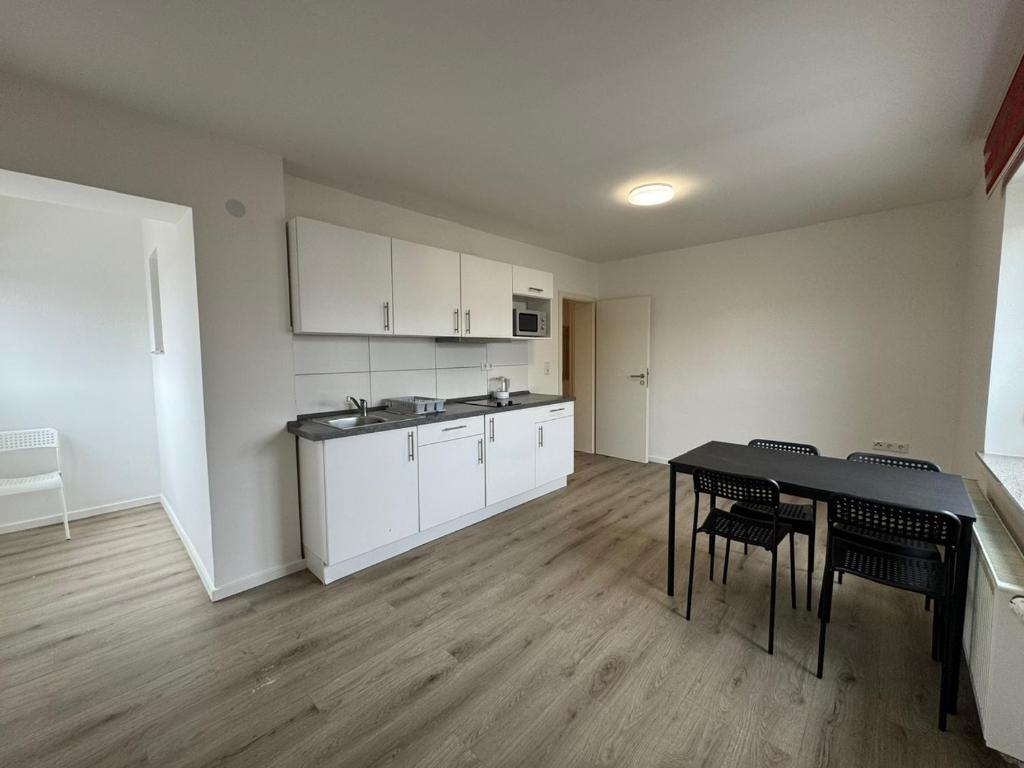 a kitchen with a table and chairs in a room at Pension Linderhof Augsburg in Augsburg