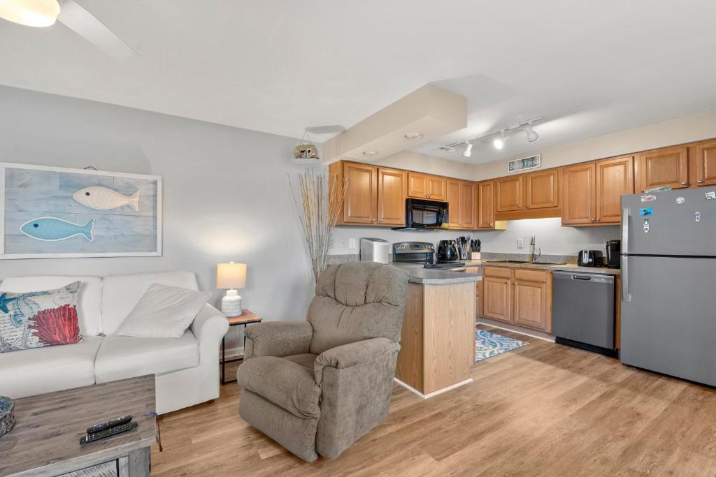 a living room with a couch and a kitchen at Sandpiper Cay 706 in Kitty Hawk