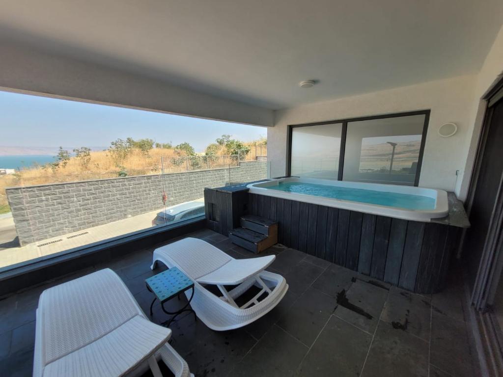 a room with a swimming pool and a table and chairs at סי כנרת- דירות עם בריכה פרטית מבית בלו מגדל in Migdal