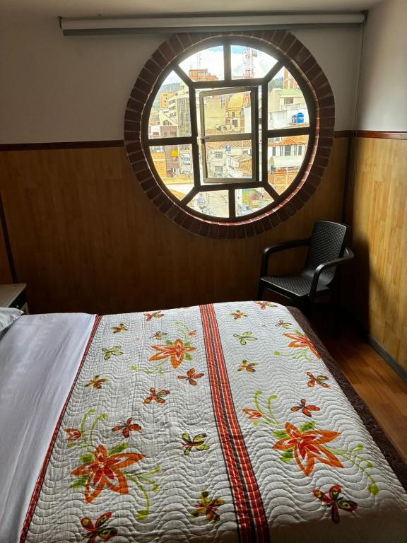 a bedroom with a bed with a blanket with a window at Hotel Tropical Club in Estación El Salto