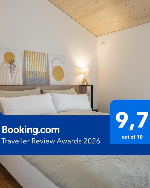 a bedroom with a bed with a blue sign that reads travelling review awards at KopfRausch Appartements in Feldkirch