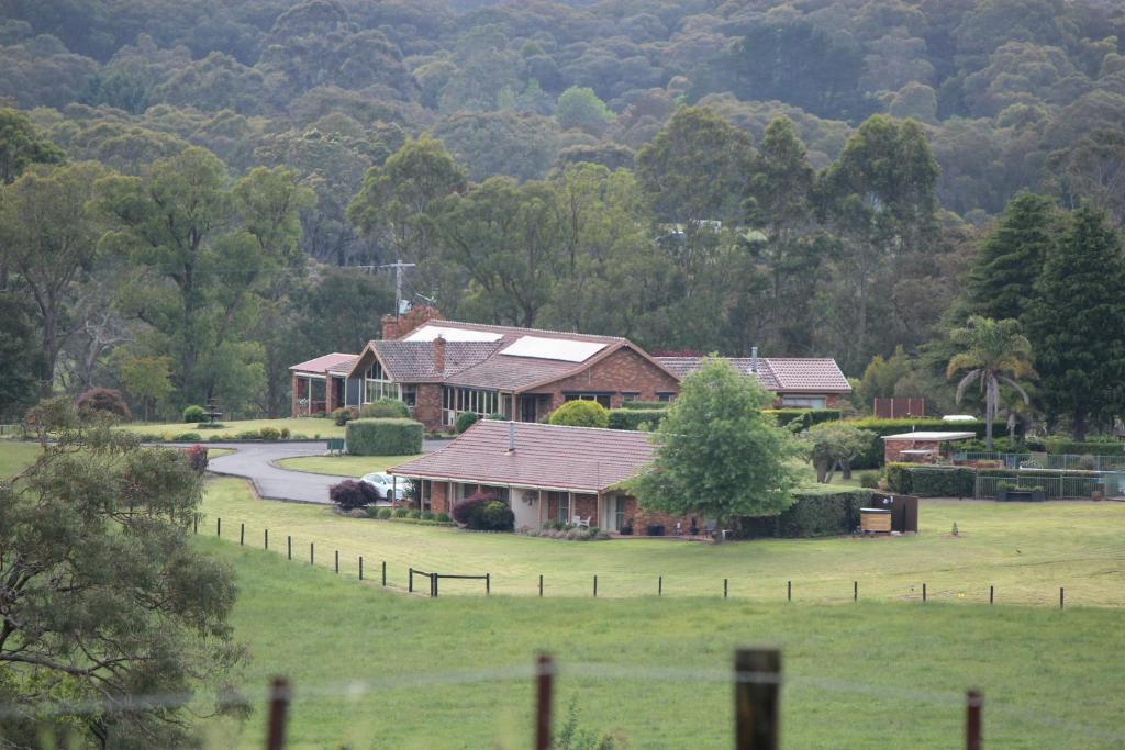 a house in the middle of a field at The Cottage-Gather the crew or the family and prepare for fun times and relaxation. Making memories in Yarra Junction