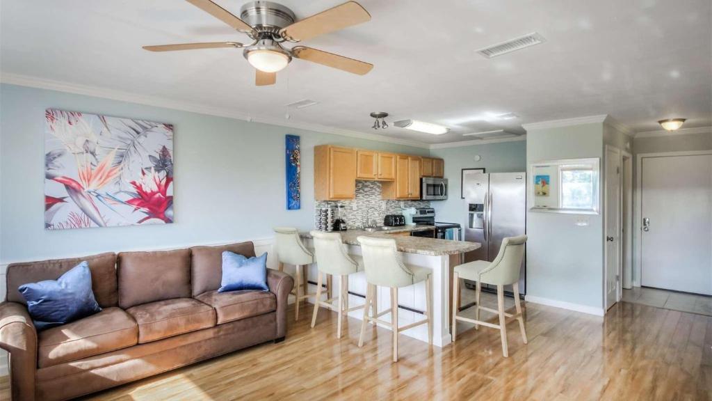 a living room with a couch and a kitchen at Canal Place 206 in Destin