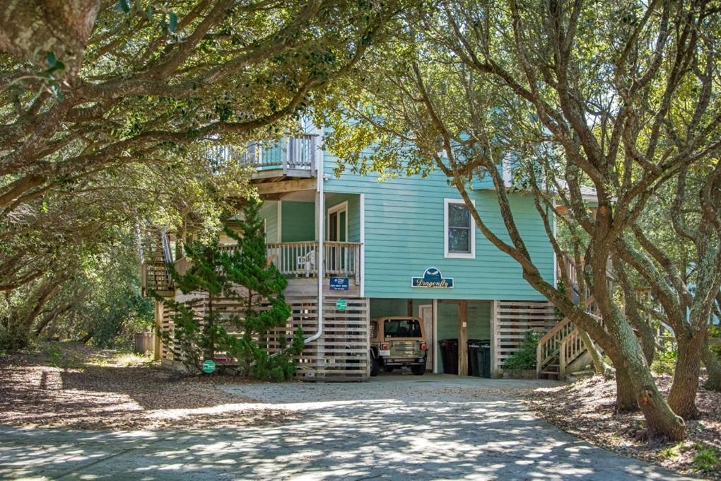 a blue house with a car parked in front of it at Dragonfly in Southern Shores