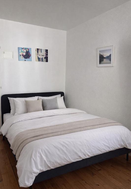 a white bedroom with a large bed in it at Central & Tranquil by Cathedral in Fribourg