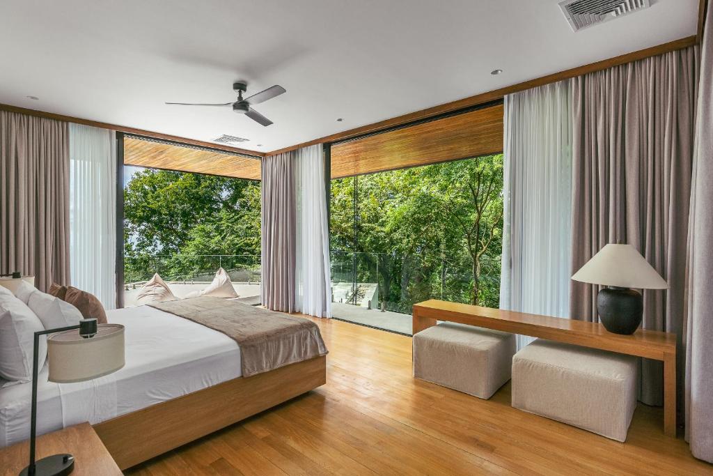a bedroom with a bed and a large window at Tenowi Villa in Mal País