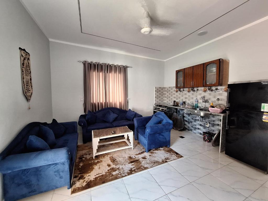 a living room with two blue couches and a table at El Hady Guesthouse in Luxor