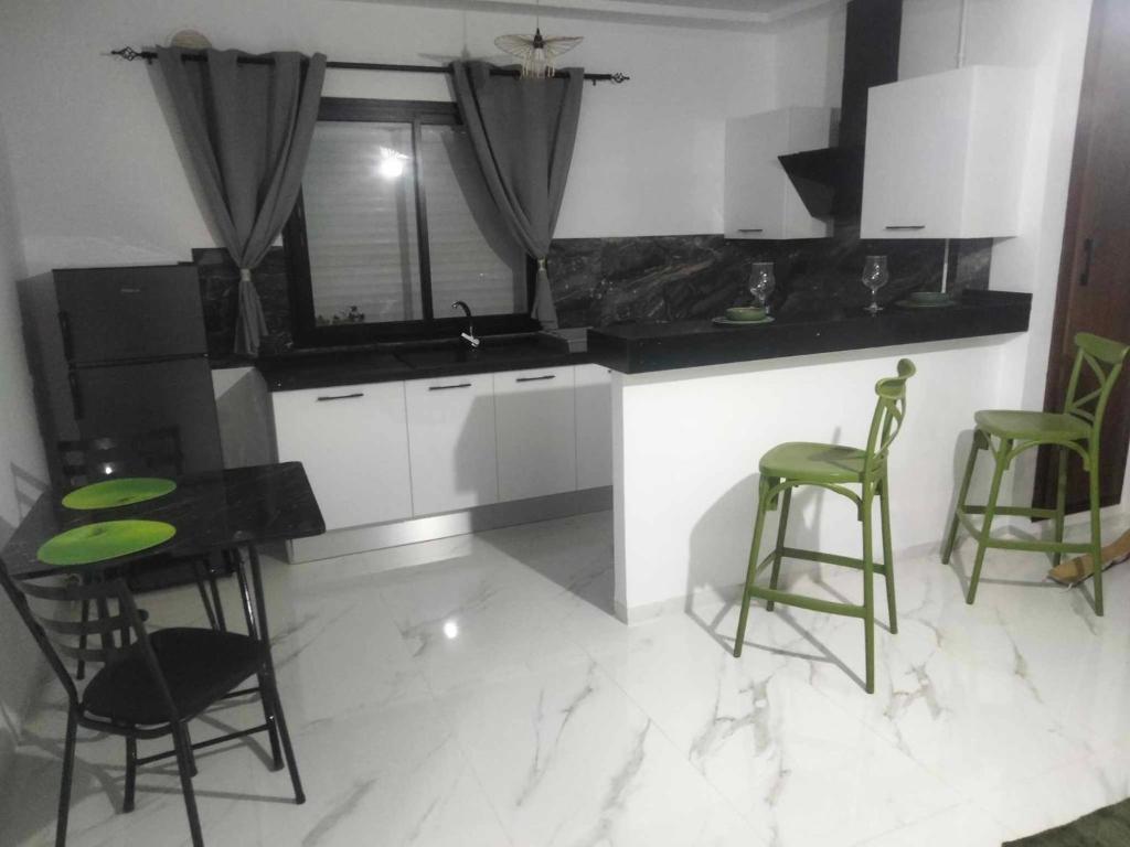 a kitchen with two green stools and a counter at Cerises in El Aouina Station