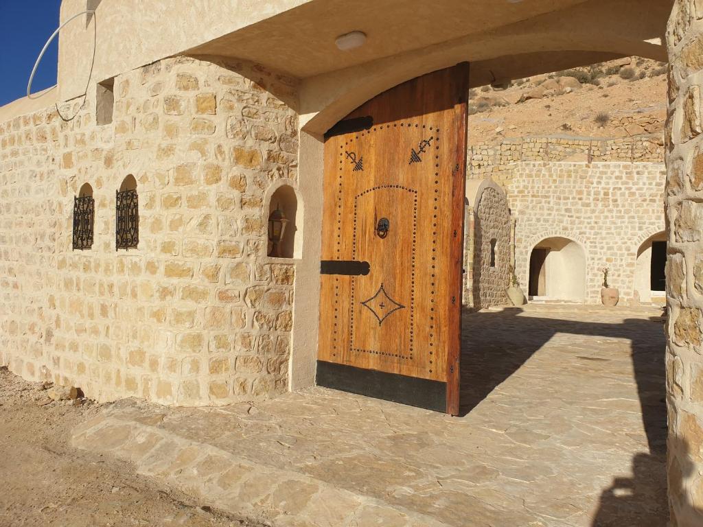 a wooden door on the side of a brick building at Dar Zmen Toujane in Tūjān