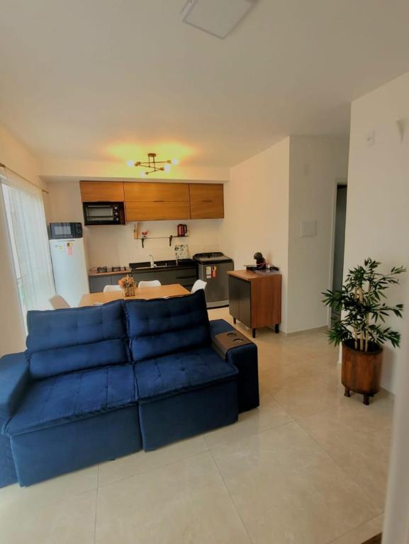 a living room with a blue couch and a kitchen at Apartamento com estacionamento in Uruguaiana