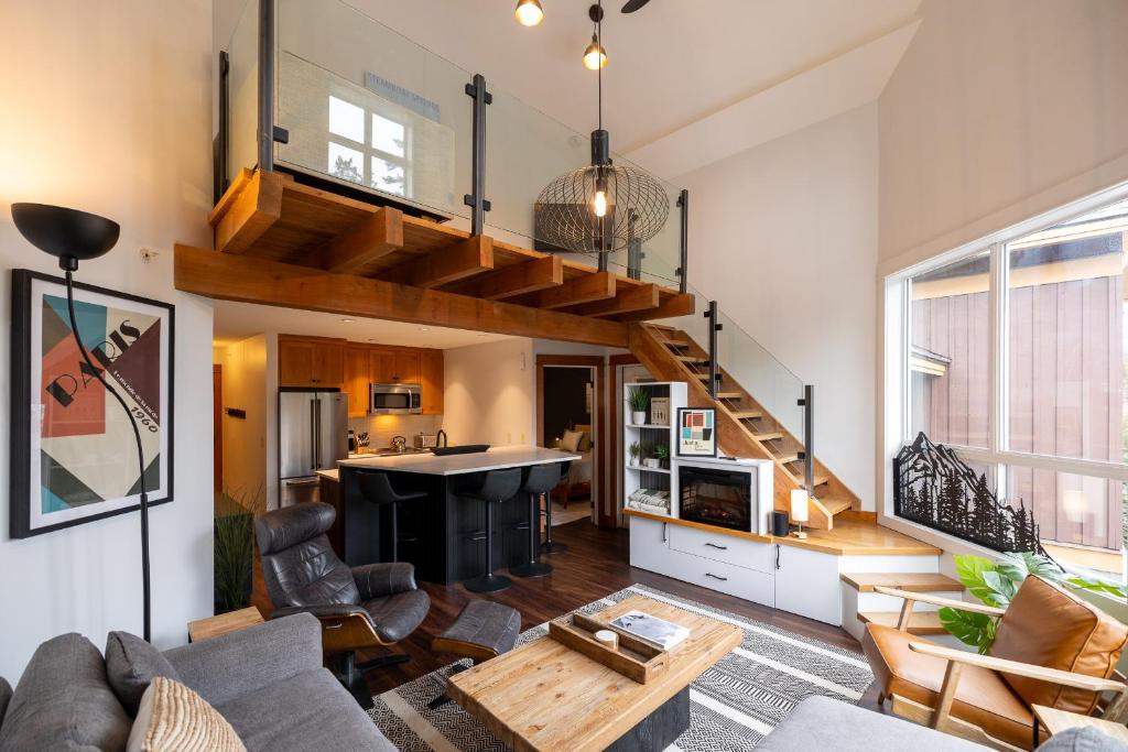 a living room with a staircase in a loft at Fully Renovated Penthouse Loft at Fernie Alpine Resort in Fernie