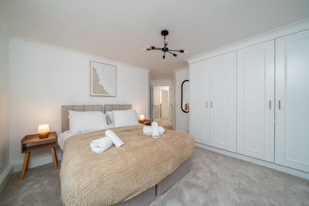 a bedroom with a large bed with towels on it at 2 Bed Flat in Woking Central in Woking