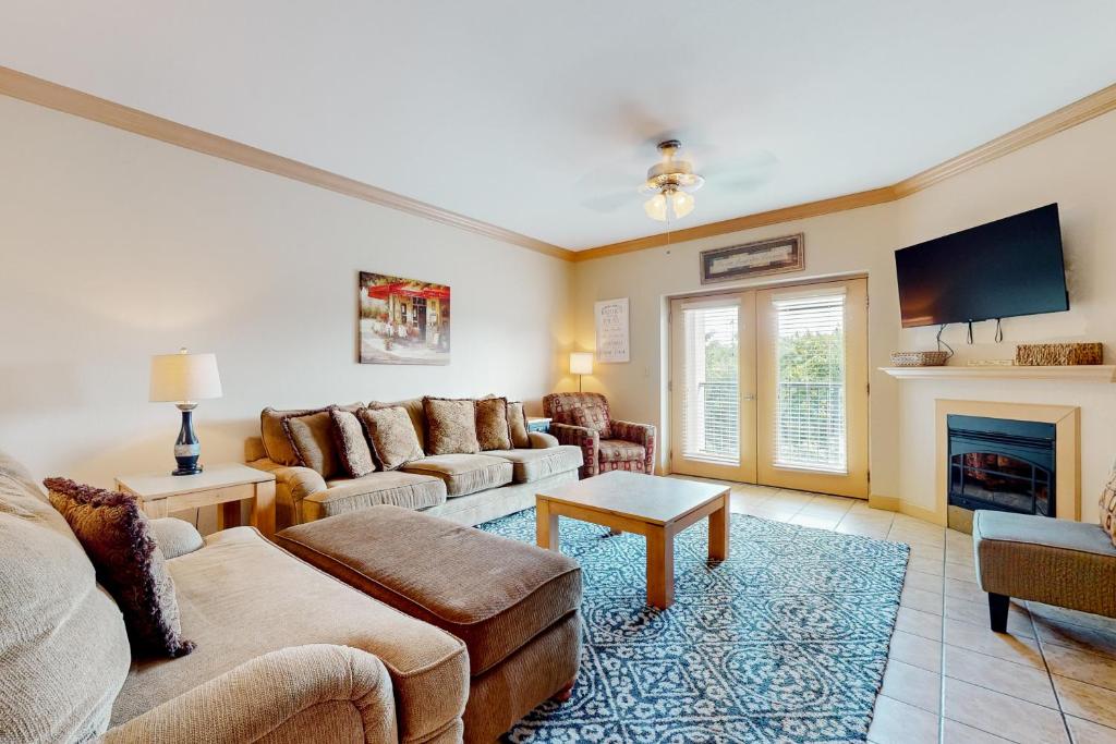 a living room with a couch and a fireplace at Charming Condo W Shared Pools Sleeps 6 Playground in Pigeon Forge