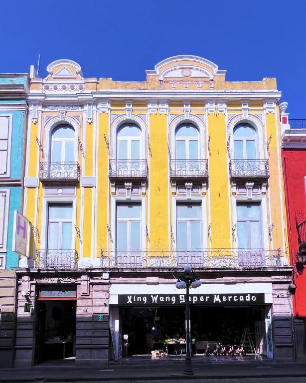 a yellow building with a sign on it at Hotel Alhaja Puebla Centro Histórico in Puebla