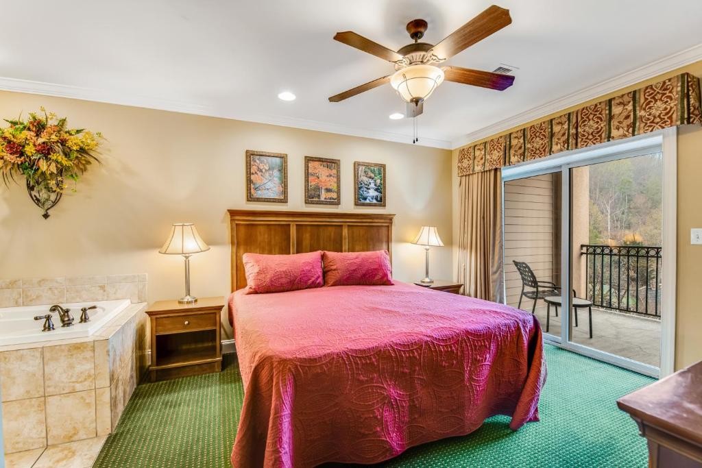 a bedroom with a bed and a tub and a sink at Downtown Summit Manor Sleeps 8 Mtn Views Pool in Gatlinburg