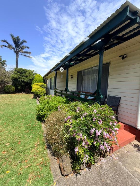 a house with a porch with flowers in the yard at Genesta House in Cowes