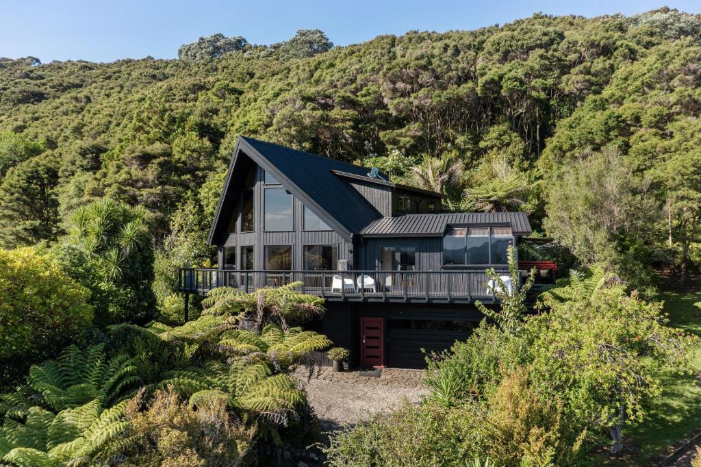 a house in the middle of a mountain at The Black Chalet in Whitianga