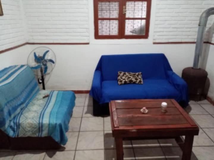 a living room with a blue couch and a table at Isabella in Xuí