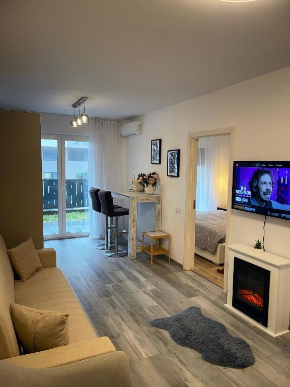 a living room with a couch and a fireplace with a tv at Urban Haven Apartment in Oradea