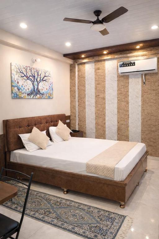 a bedroom with a bed and a ceiling fan at Hotel In Varanasi in Varanasi