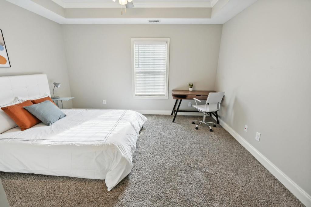 a white bedroom with a bed and a desk at Properties by Preston I 2Bd2bth Townhome in Clarksville