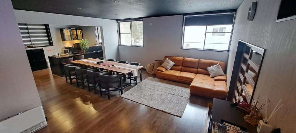 a living room with a couch and a table and chairs at Yuki Lodge Myoko in Myoko