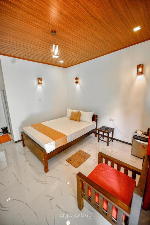 a bedroom with a bed and a chair in a room at Eden Udawalawe in Udawalawe