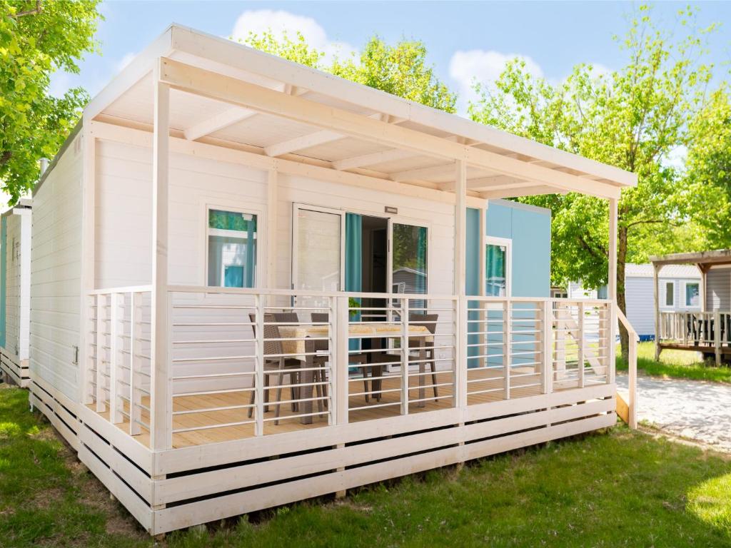 a small white house with awning on a yard at great mobile home in Cesenatico in Cesenatico