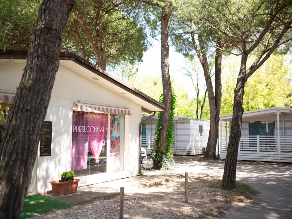 a white building with trees in front of it at Cozy mobile home in Cesenatico in Cesenatico