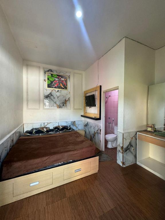 a bedroom with a large bed and a bathroom at PONDOK CHILLY in Cirebon