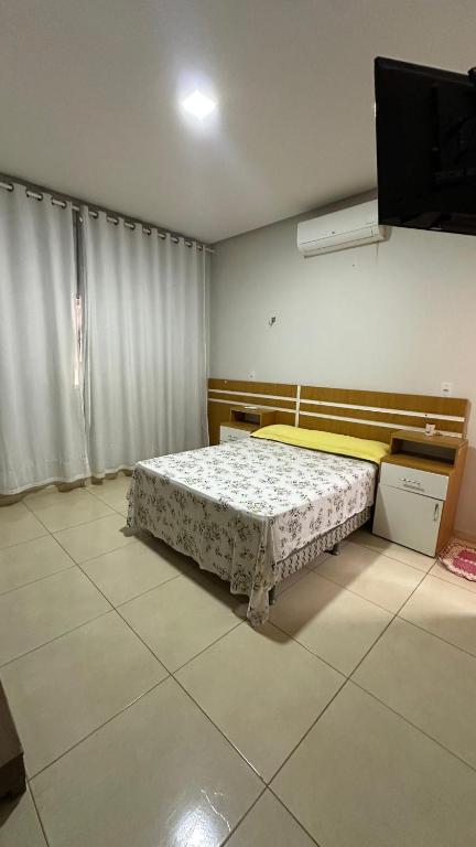 a bedroom with a bed and a television in it at Casa familiar no Campestre, tranquila e bem localizada in São Raimundo Nonato