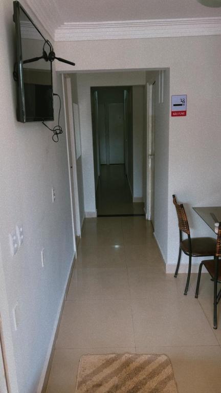 a hallway with a table and a television on a wall at Pousada 705 Norte 3 in Brasília