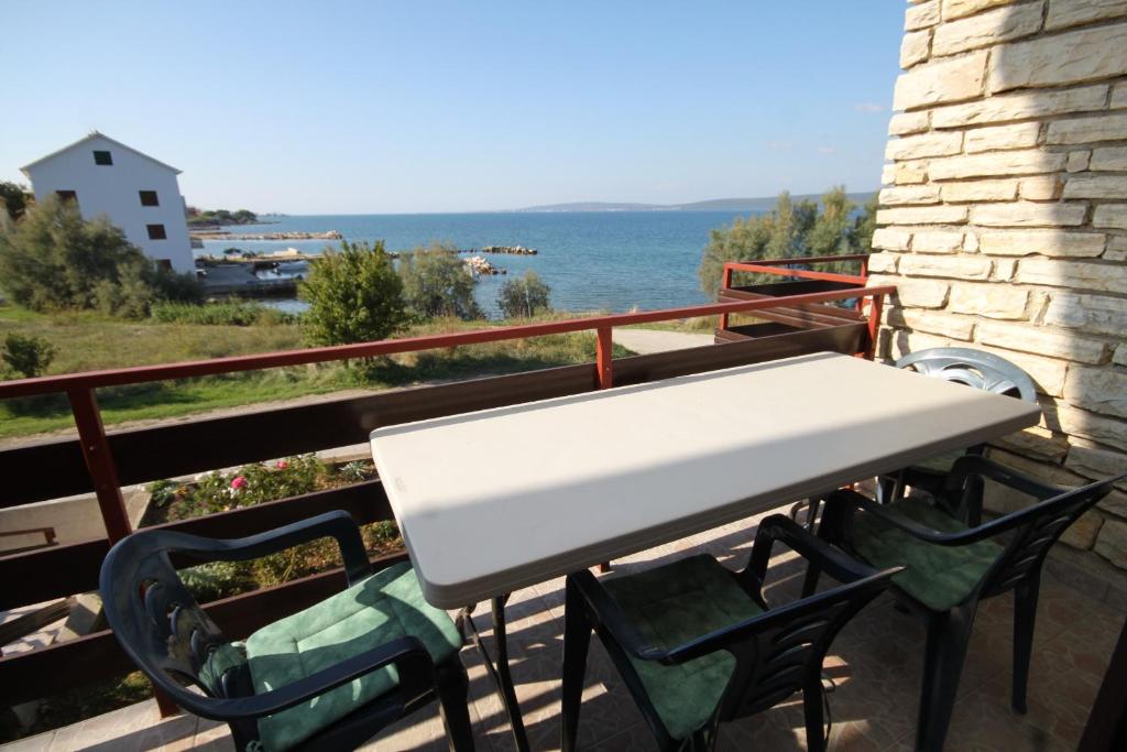 a table and chairs on a balcony with the ocean at Apartment Nevidjane 8401a in Neviđane