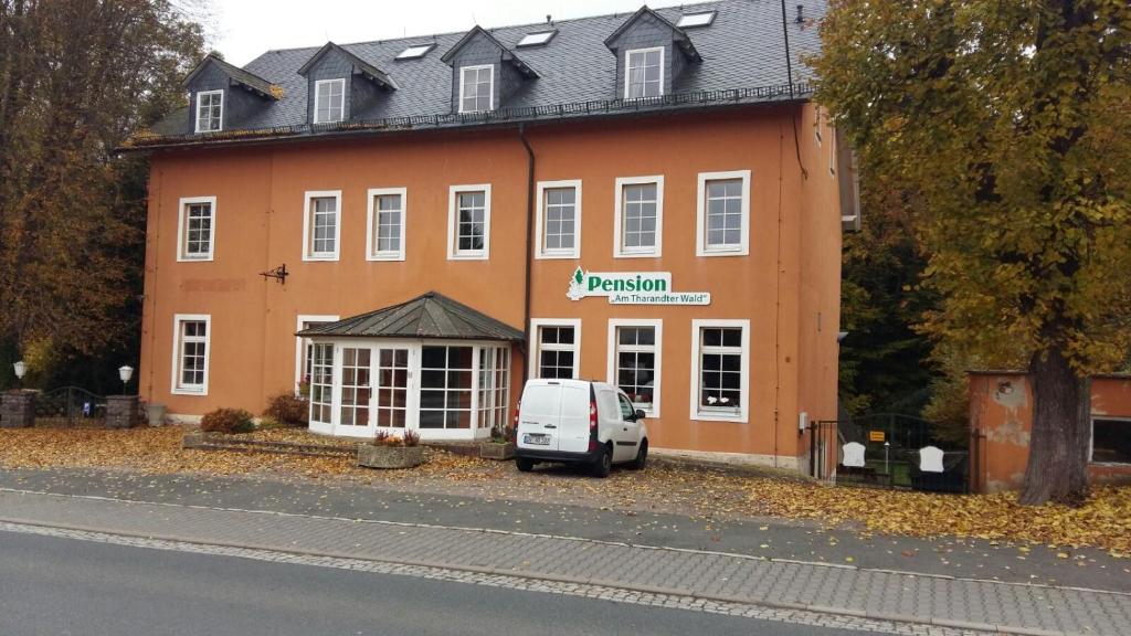 une camionnette blanche garée devant un bâtiment dans l'établissement Pension am Tharandter Wald, à Grillenburg